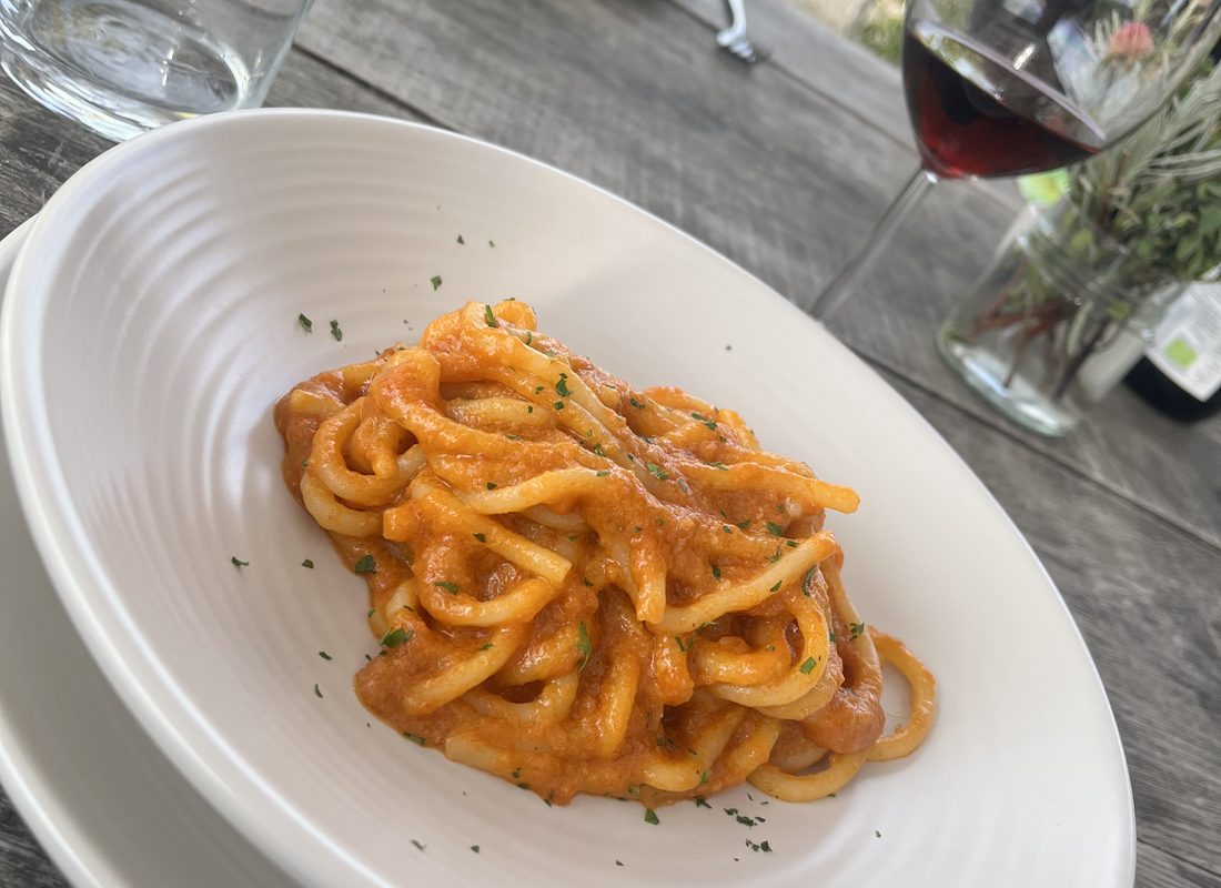 Fresh pasta in tomato sauce served with a glass of red wine