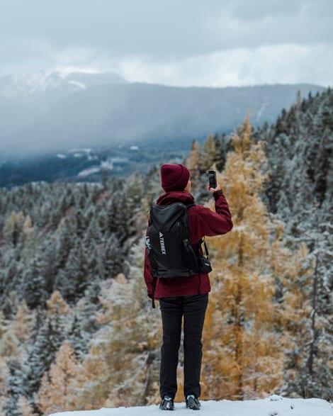 Hiker looking out over a snowy mountain forest