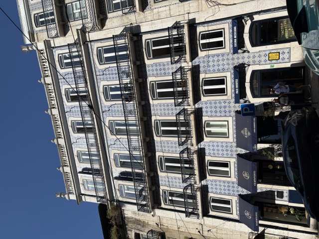 Traditional blue-and-white azulejo-tiled facade of a historic Lisbon townhouse with wrought-iron balconies